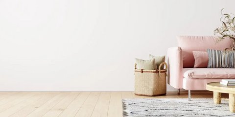 Minimalistischer Raum mit rosa Sofa, hellem Holzboden und einfacher, pastelfarbender Deko.