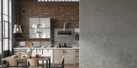 industrielle Küche mit Schränken, Geräten und Essbereich. Daneben einer graue betonwand.