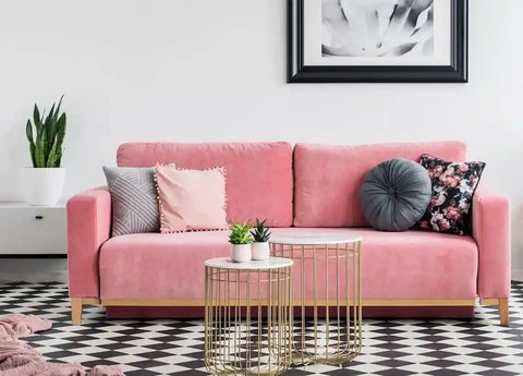 Rosa Sofa mit Kissen, goldenem Couchtisch,Karo- Boden und Pflanzen.